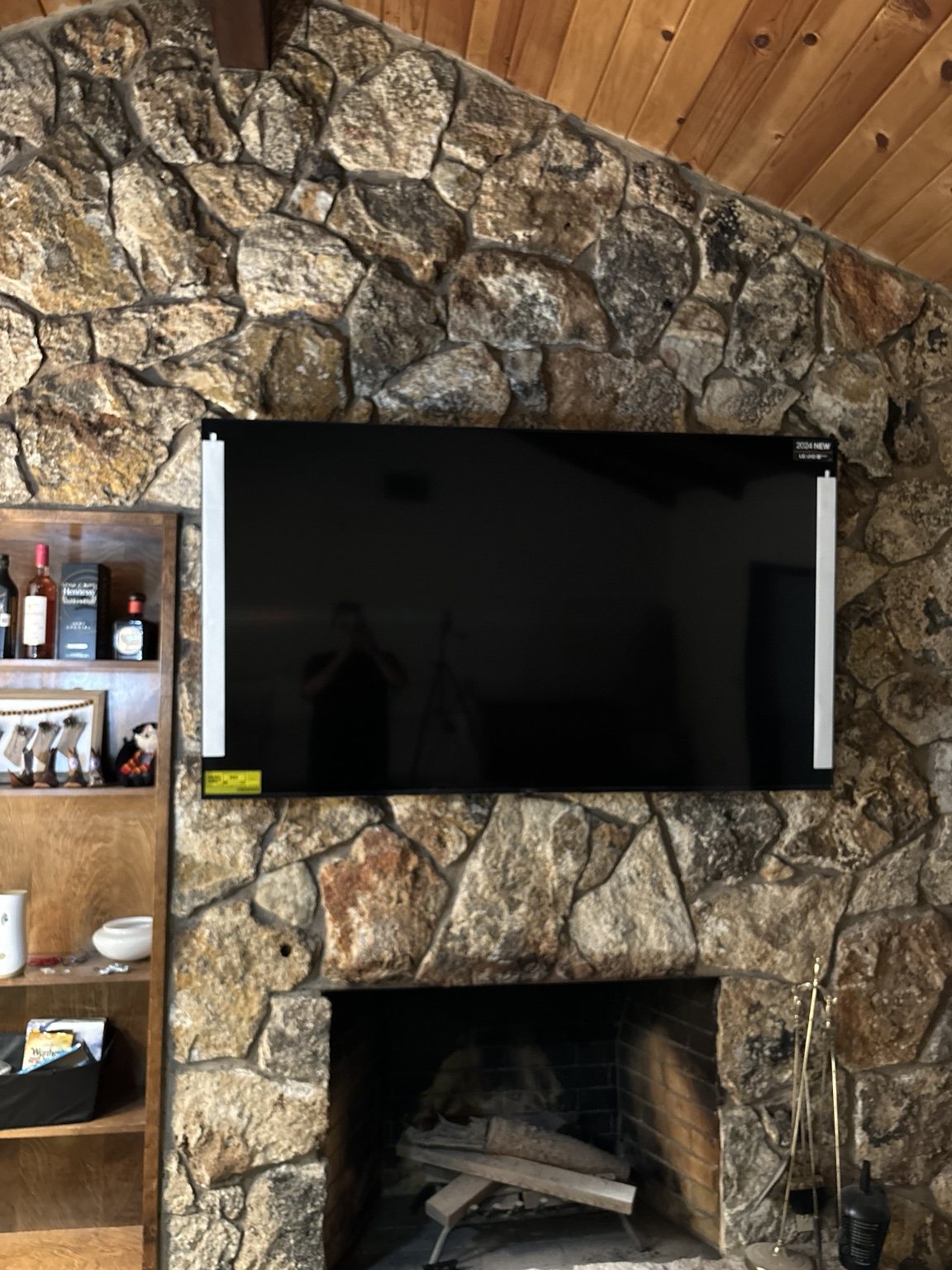 Television mounted on a stone fireplace wall